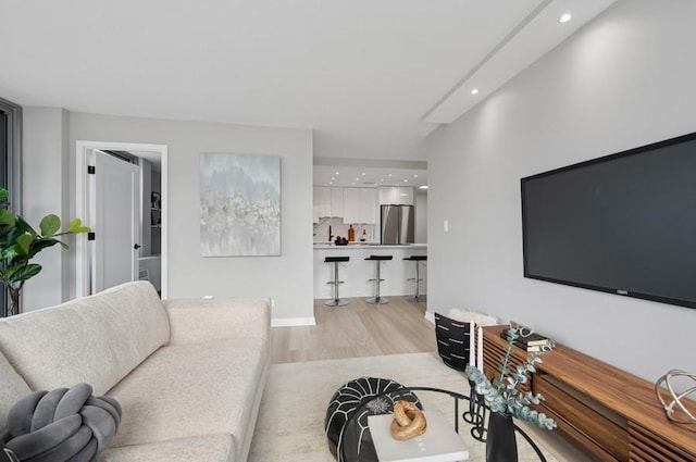 living room with light wood-style flooring, baseboards, and recessed lighting