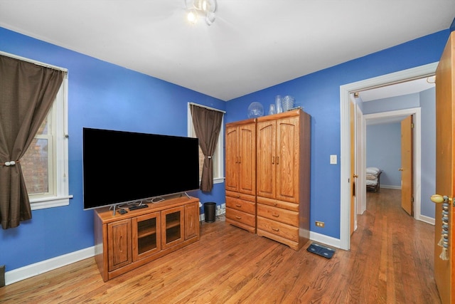 bedroom with light wood finished floors and baseboards