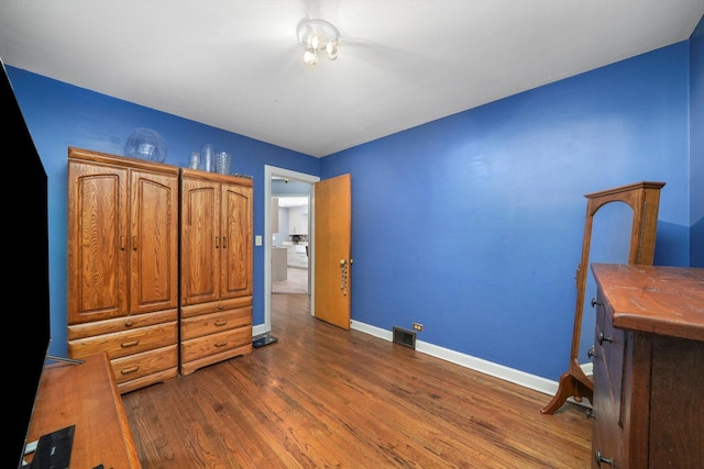 bedroom with dark wood-style floors, baseboards, and visible vents