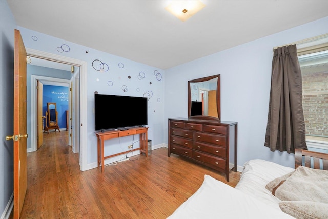 bedroom featuring baseboards and wood finished floors