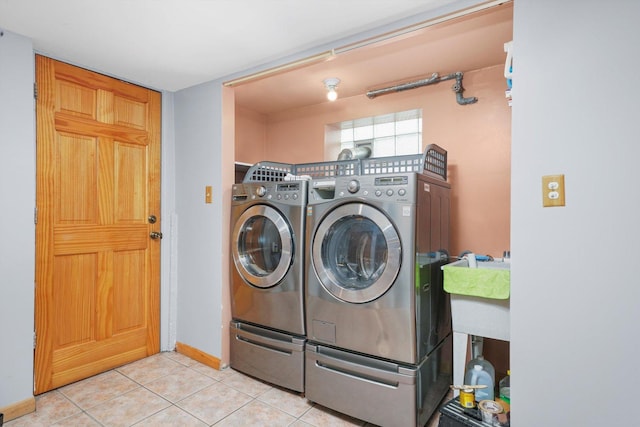 washroom with tile patterned flooring, baseboards, and washing machine and clothes dryer