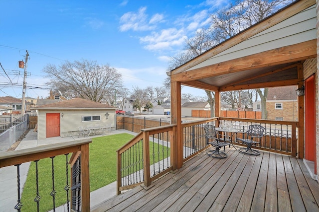 wooden terrace with a yard, a fenced backyard, a residential view, and an outbuilding