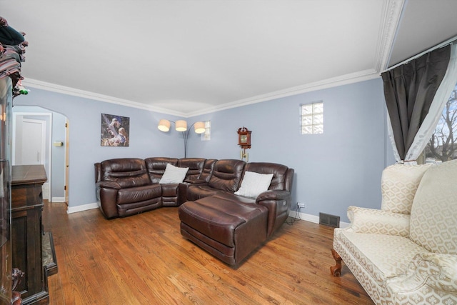 living area featuring arched walkways, ornamental molding, wood finished floors, and visible vents