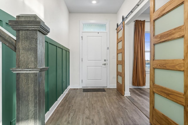 entrance foyer with a barn door, baseboards, and dark wood-style flooring