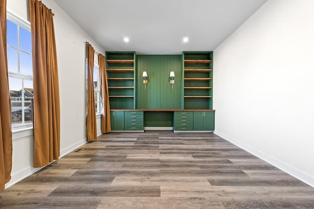 interior space with built in desk, recessed lighting, wood finished floors, and baseboards