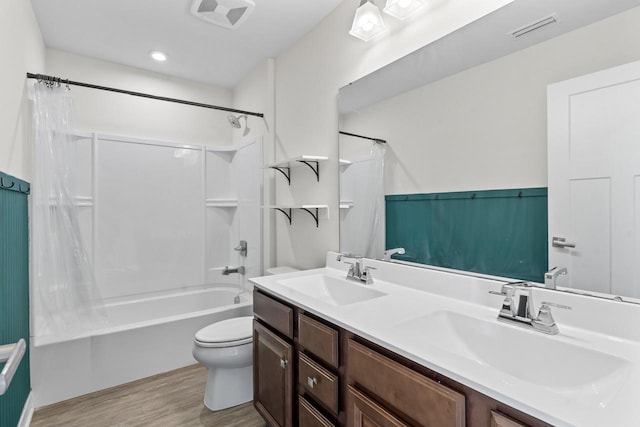 full bathroom with toilet, visible vents, a sink, and wood finished floors