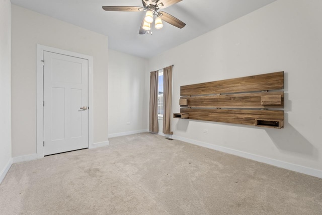 unfurnished room featuring carpet, baseboards, and ceiling fan