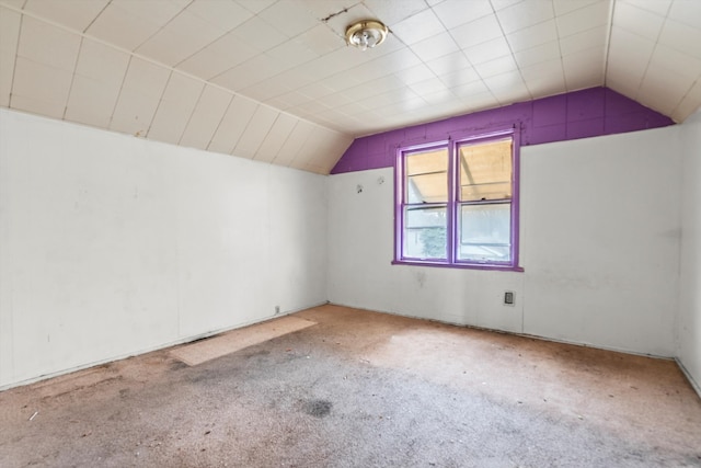 additional living space featuring vaulted ceiling and carpet flooring