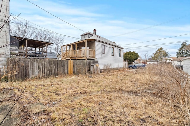 view of side of property with a chimney and fence