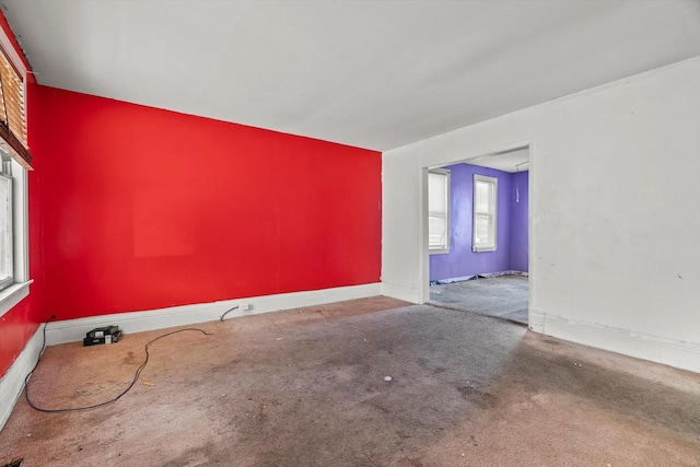 carpeted spare room featuring baseboards