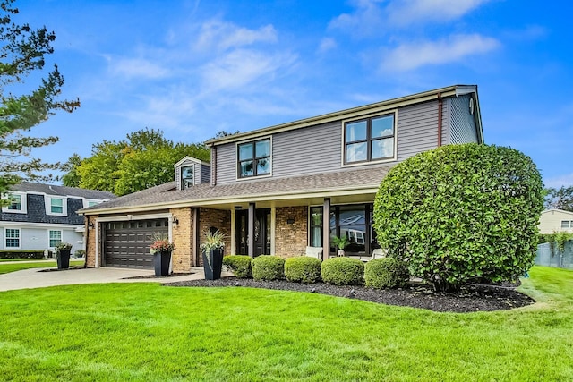 traditional-style home with a garage, a front yard, concrete driveway, and brick siding