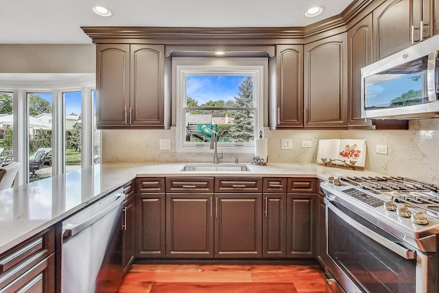 kitchen featuring decorative backsplash, recessed lighting, stainless steel appliances, and a sink