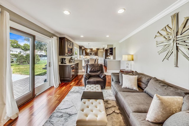 living area featuring crown molding, recessed lighting, and light wood-type flooring