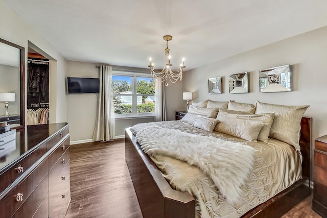 bedroom featuring dark wood finished floors, a chandelier, and baseboards