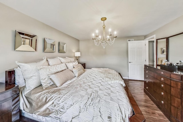 bedroom with visible vents, baseboards, dark wood-type flooring, and an inviting chandelier