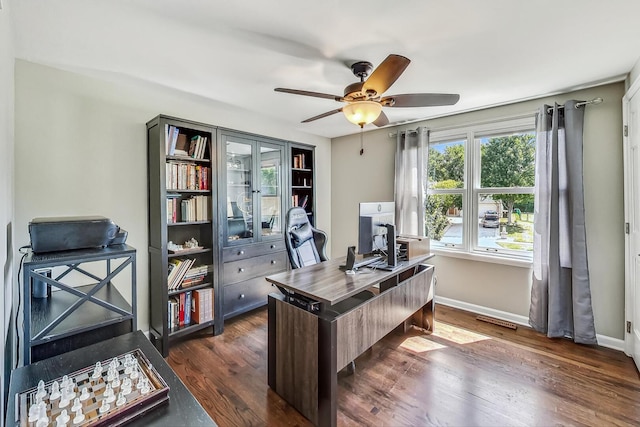 home office with visible vents, baseboards, dark wood-style flooring, and ceiling fan