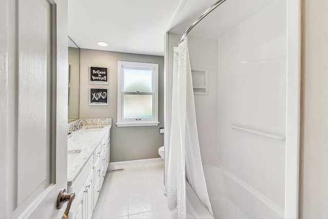 full bath with baseboards, toilet, double vanity, tile patterned floors, and a sink