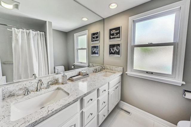 full bath featuring tile patterned flooring, toilet, and a sink