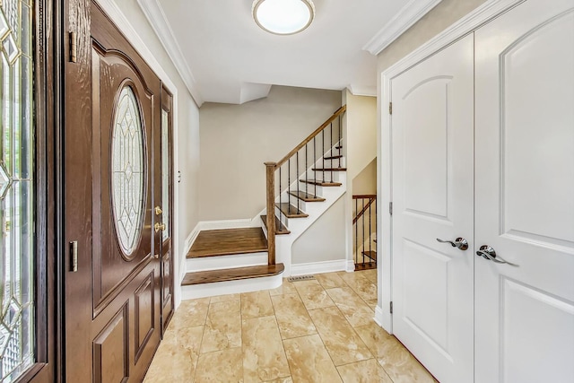 foyer entrance with stairs, baseboards, and ornamental molding