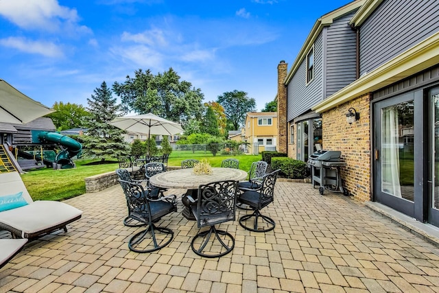 view of patio with grilling area, outdoor dining space, and fence