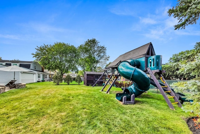 community play area featuring an outbuilding, a yard, and fence