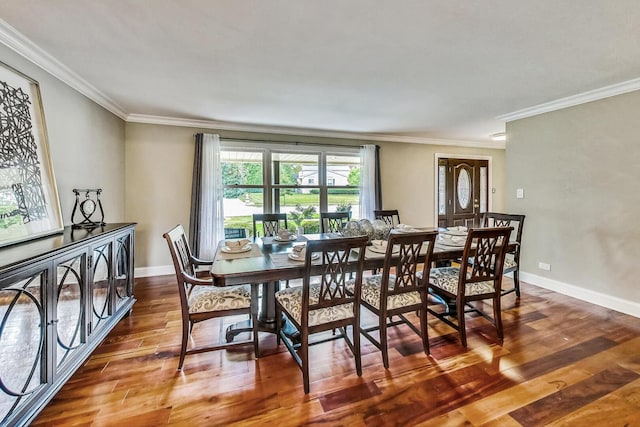 dining space featuring crown molding, wood finished floors, and baseboards