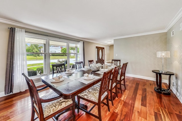 dining area featuring dark wood-style floors, baseboards, and ornamental molding