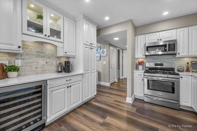 kitchen with stainless steel appliances, beverage cooler, light countertops, and white cabinets