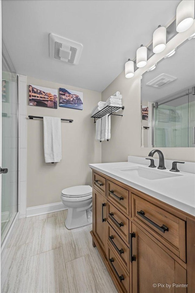 full bathroom featuring visible vents, toilet, a shower stall, vanity, and baseboards