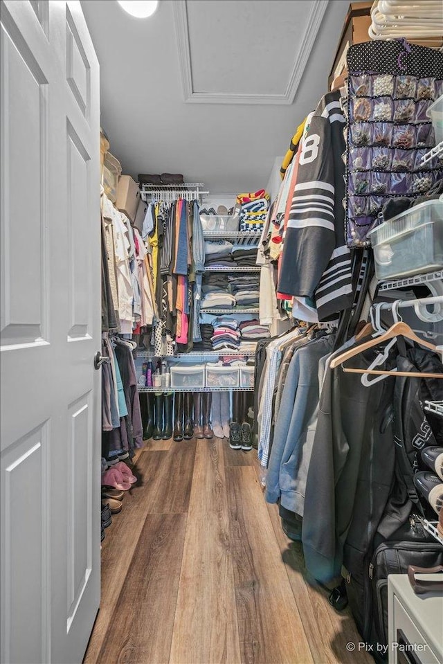 spacious closet with wood finished floors and attic access