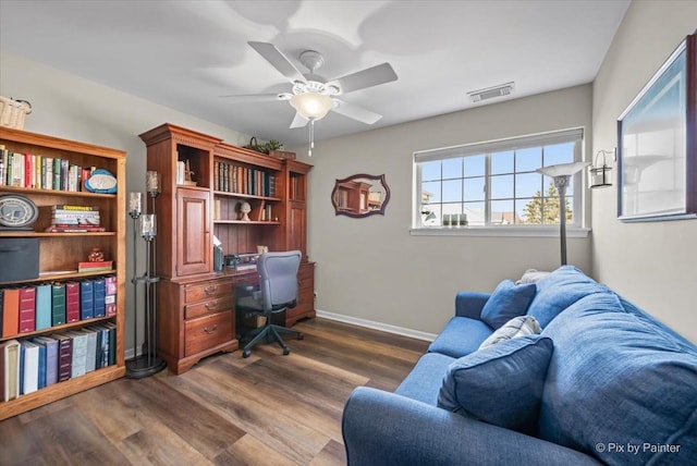 office area with visible vents, dark wood finished floors, baseboards, and ceiling fan