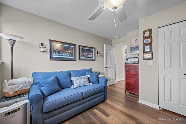 living room with ceiling fan, baseboards, and dark wood-style flooring