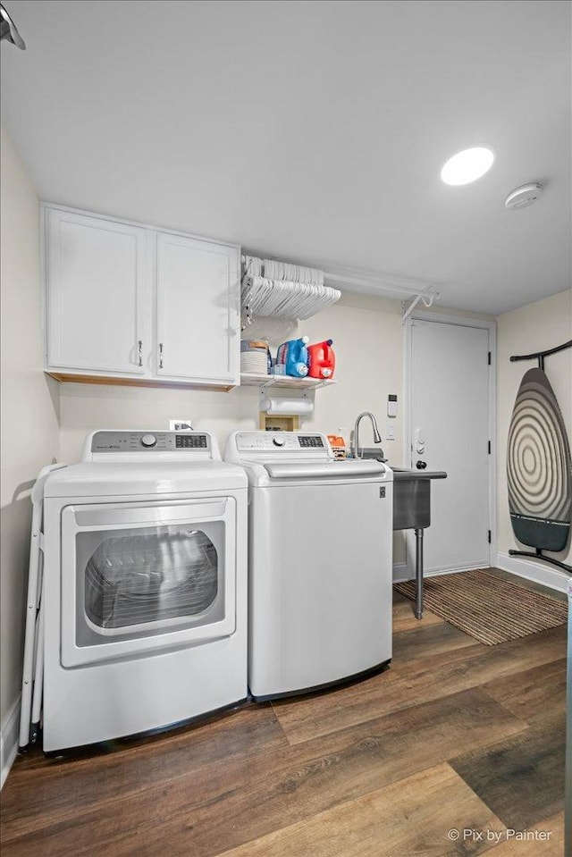 washroom featuring dark wood-style flooring, independent washer and dryer, a sink, and cabinet space