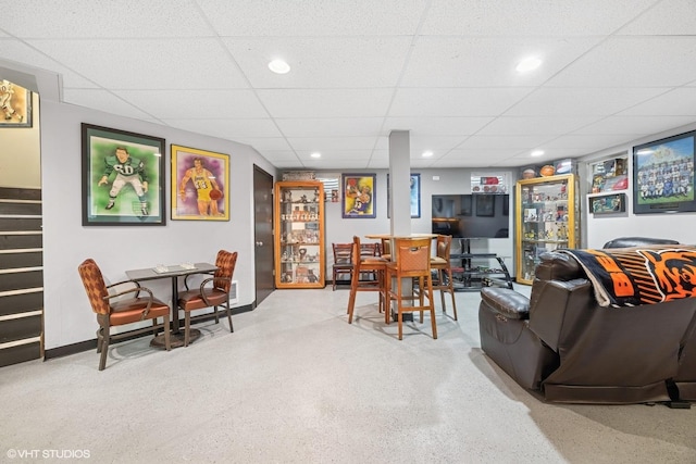 living area featuring baseboards, a paneled ceiling, and recessed lighting