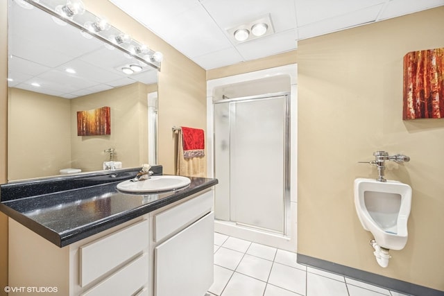 bathroom featuring vanity, a stall shower, tile patterned flooring, and a paneled ceiling