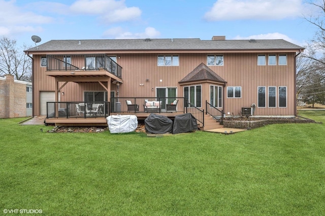 rear view of property with a wooden deck, a shingled roof, and a yard