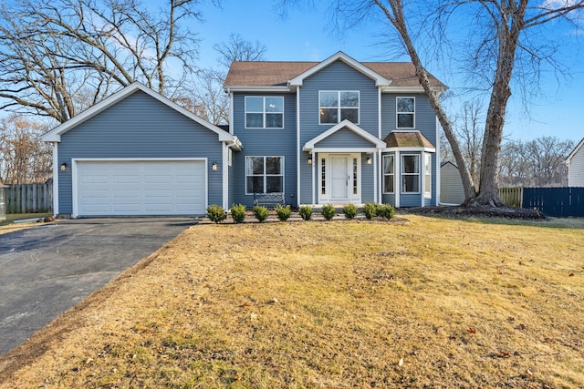 view of front of property featuring aphalt driveway, a front lawn, fence, and an attached garage