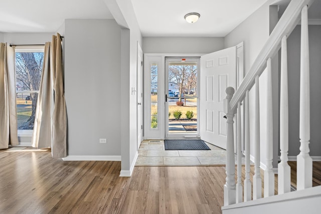 entryway featuring a healthy amount of sunlight, stairway, and wood finished floors