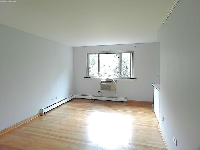 empty room featuring a wall unit AC and light wood-style floors