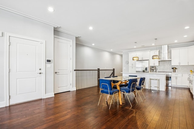 dining room with dark wood finished floors, recessed lighting, and ornamental molding