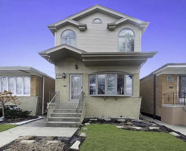 view of front of house featuring brick siding and a front yard