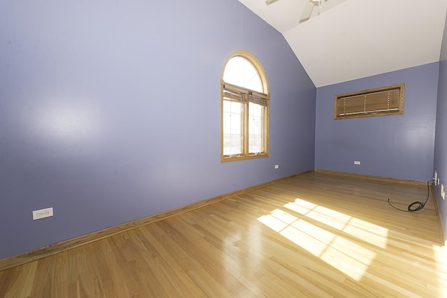 spare room with vaulted ceiling, ceiling fan, wood finished floors, and baseboards