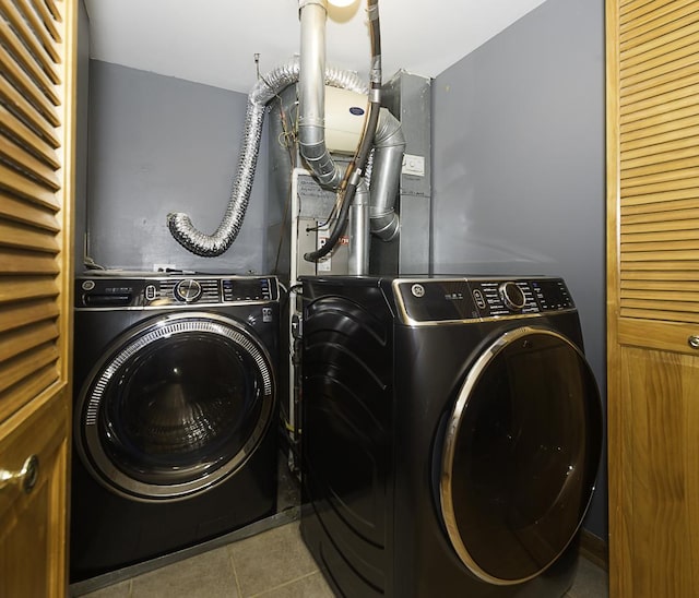 laundry room featuring laundry area, tile patterned flooring, and washing machine and dryer