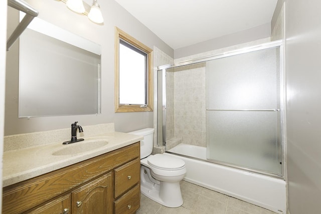 full bathroom featuring tile patterned flooring, shower / bath combination with glass door, vanity, and toilet