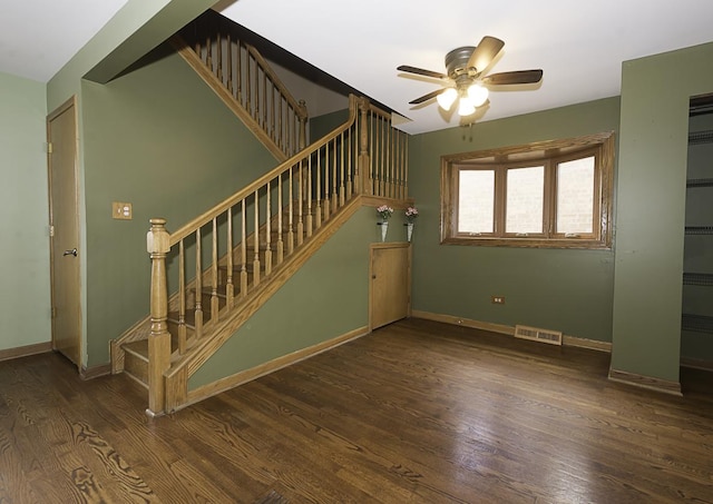 stairs featuring a ceiling fan, visible vents, baseboards, and wood finished floors