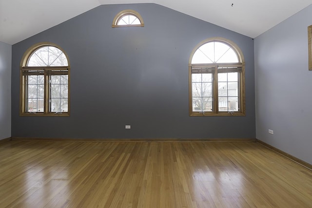 unfurnished room featuring vaulted ceiling and plenty of natural light