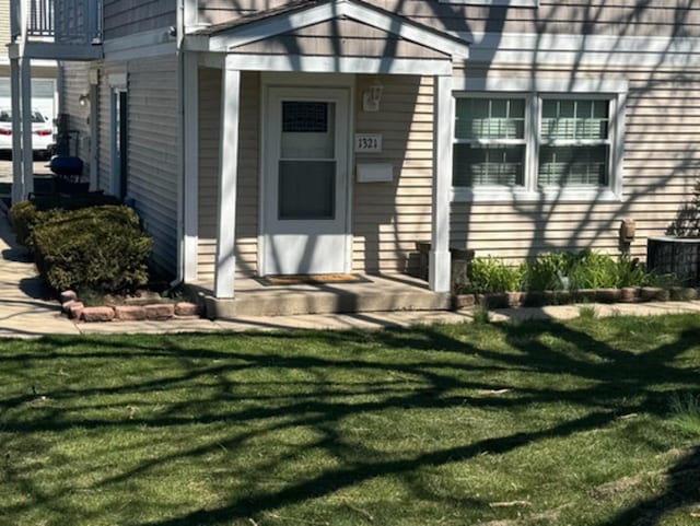 entrance to property featuring a lawn