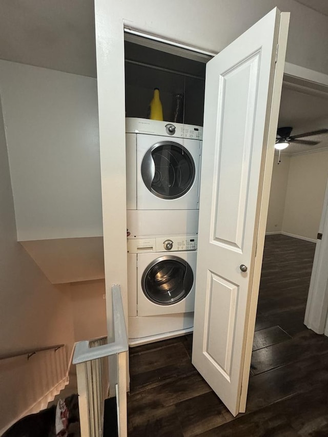 laundry area with dark wood finished floors, laundry area, stacked washer / drying machine, and a ceiling fan