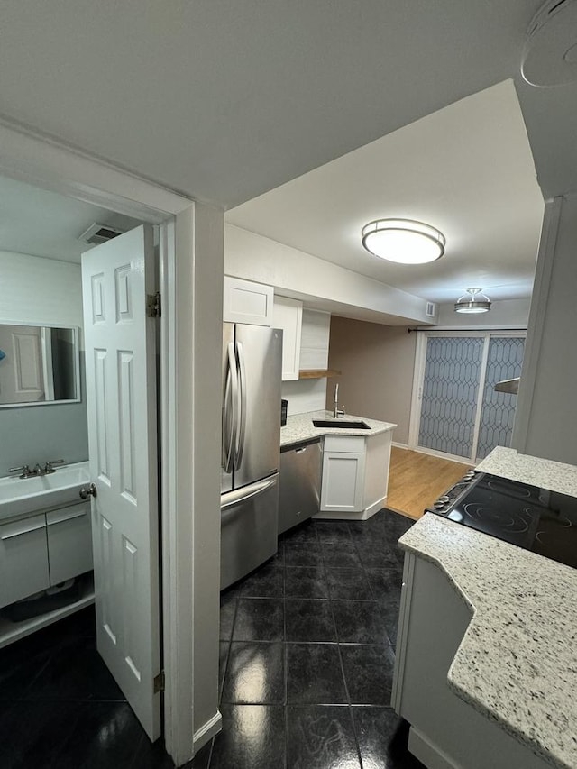 kitchen with visible vents, light countertops, appliances with stainless steel finishes, white cabinets, and a sink