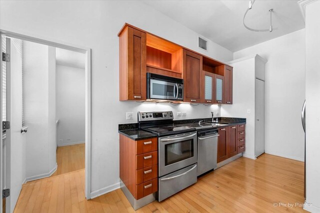 kitchen featuring light wood-style floors, visible vents, stainless steel appliances, and a sink